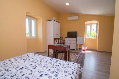 a bedroom with a bed and a desk and a tv at Luisa S2 room B in Veli Lošinj