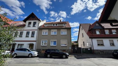 zwei Autos, die auf einem Parkplatz vor den Gebäuden geparkt sind in der Unterkunft A2 - Viel Platz für alle in Wernigerode