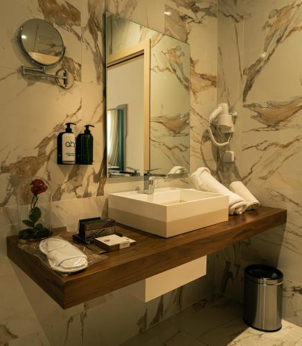 a bathroom with a sink and a mirror at Le Royal Plaza in Kenitra