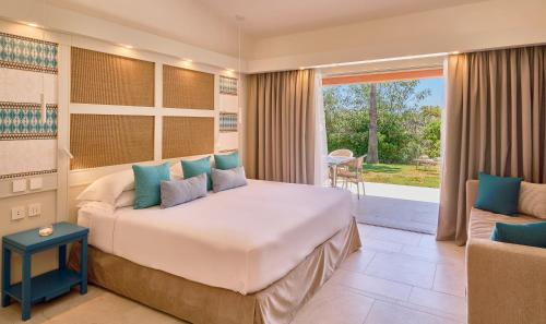 a bedroom with a large bed and a patio at Residence Le Bouganville in Villasimius