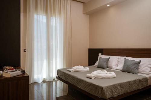 a bedroom with two towels on a bed with a window at Stella Ví in Cefalù