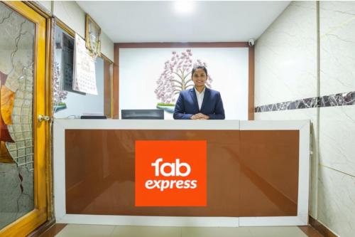 Eine Frau steht hinter einem Empfangstresen mit einem Ford Express-Schild. in der Unterkunft Via Le Royal Inn in Chennai