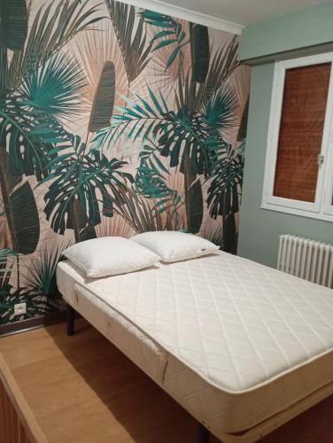 a bed in a room with a wall with plants at La colline de pam la belle vue in Cornimont