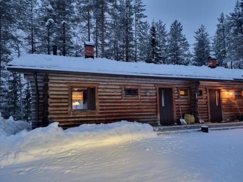 eine Blockhütte im Schnee, umgeben von Schnee in der Unterkunft Ylläs Valokki - sauna, fireplace, Ylläs view in Ylläsjärvi