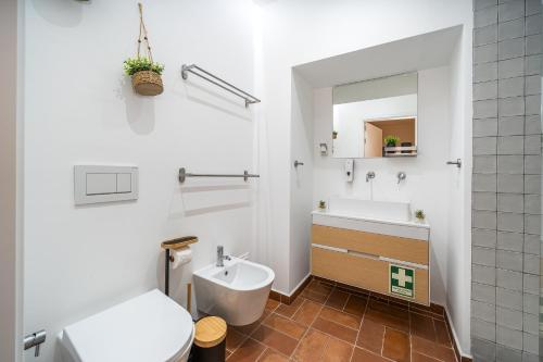 een badkamer met een wastafel, een toilet en een spiegel bij Apartamento Karolvaz V in Silves