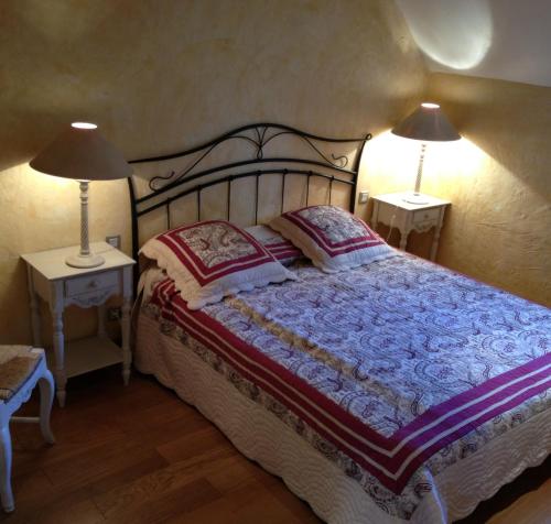 1 dormitorio con 1 cama con 2 lámparas en 2 mesas en Belveyre à Rocamadour en Rocamadour