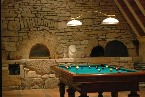 una mesa de billar en una habitación con una pared de piedra en Belveyre à Rocamadour en Rocamadour