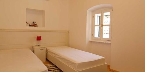 a small bedroom with two beds and a window at Mariana B4 in Veli Lošinj