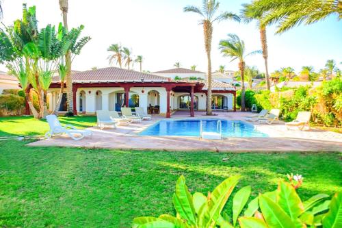 una casa con piscina y palmeras en Rooms and villas in Sheraton Sharm el Sheikh, en Sharm El Sheikh