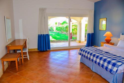 Un dormitorio con una cama y un escritorio y una ventana. en Rooms and villas in Sheraton Sharm el Sheikh, en Sharm El Sheikh