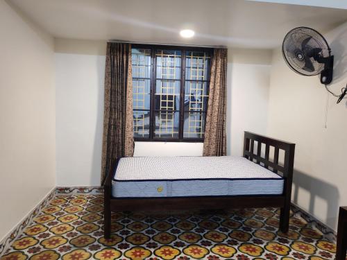 a small bed in a room with a window at The Sparrow House 2BHK Ground Floor in Kumbakonam