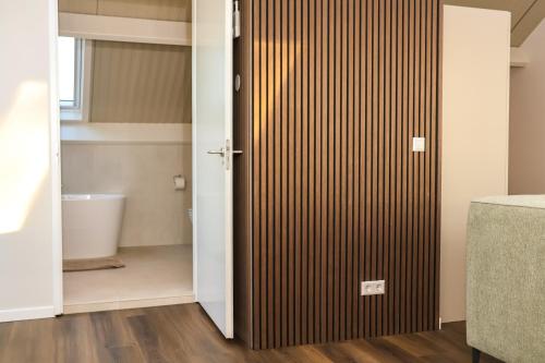 Zicht op Urk في أورك: حمام مع باب منزلق مع مرحاض