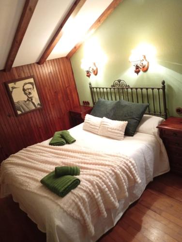 a bedroom with a bed with two green towels on it at A Casa da Rianxeira in A Pobra do Caramiñal