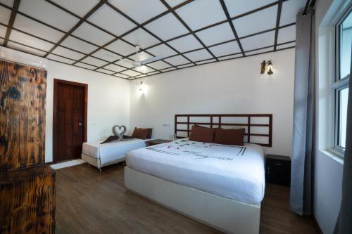 ein Hotelzimmer mit zwei Betten und einem Fenster in der Unterkunft Madivaru Kro in Rasdu
