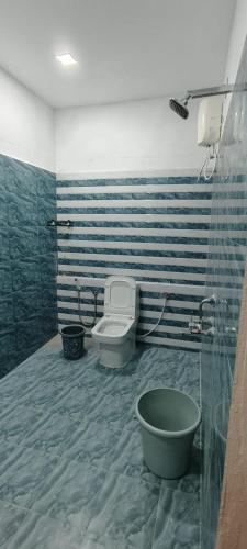 a bathroom with a toilet and a bath tub at Himalaya Pool & Resort Hotel in Tirupati
