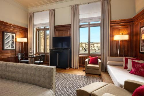 a living room with a couch and a television at Hotel De Rome Berlin in Berlin