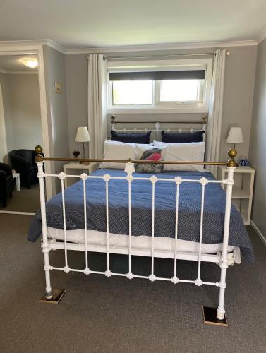 a bedroom with a white bed with a window at Heart of Deloraine in Deloraine