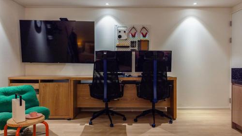 a room with a desk with two chairs and a flat screen tv at Anook Hotel Incheon Bupyeong in Incheon