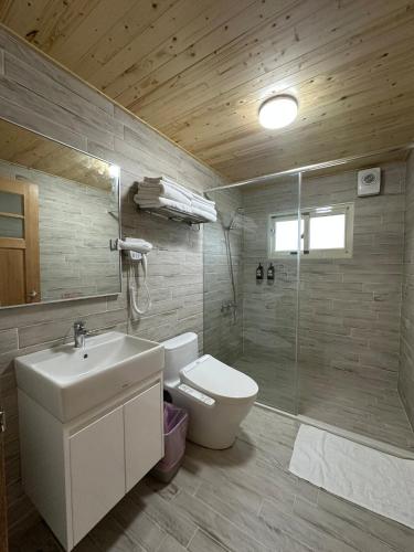 a bathroom with a toilet and a sink and a shower at Amei's Home in Dayin