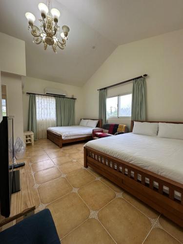 a bedroom with two beds and a chandelier at Amei's Home in Dayin