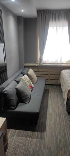 Habitación con sofá con almohadas y ventana. en Mihailo hotel Andjela, en Kopaonik