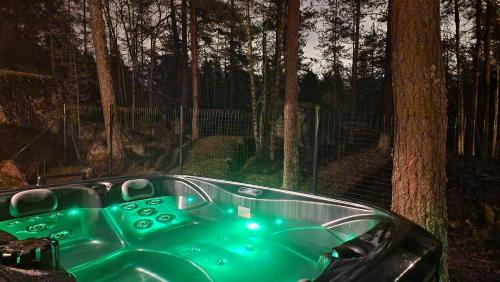 科特卡Santalahti Resort Cottages & Villas的森林里一个绿树环绕的浴缸