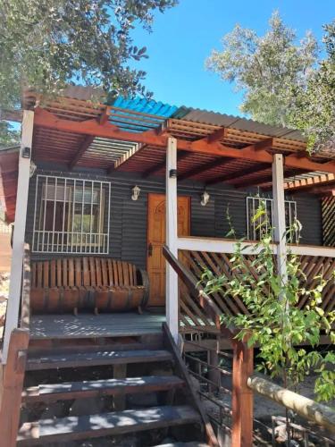 een huis met een houten trap naar een veranda bij Cabañas Armerillo in Colbún Alto