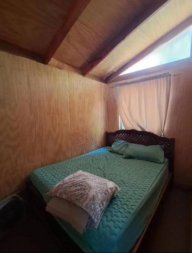 een klein bed in een kleine kamer met een raam bij Cabañas Armerillo in Colbún Alto