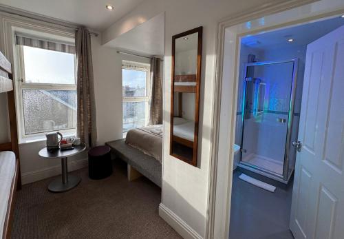 a bedroom with a bed and a mirror and a window at Reef Lodge in Newquay