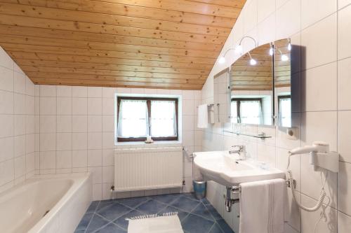 e bagno con vasca, lavandino e vasca. di Chalet a Sankt Gilgen