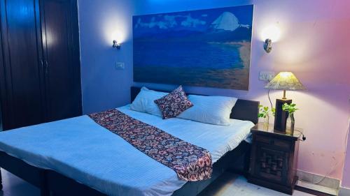 Dr Balis Bliss Homestay Sarvodya Enclave في Jāmb: غرفة نوم بها سرير مع لحاف أزرق