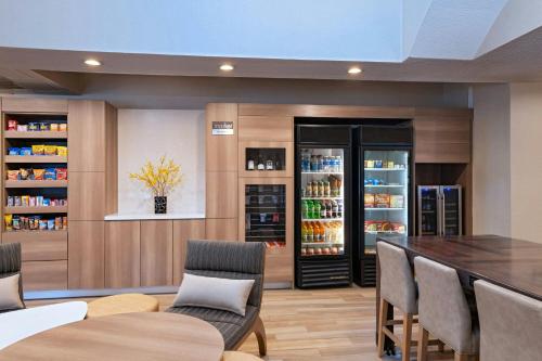 a dining room with a table and chairs and a refrigerator at Residence Inn by Marriott Houston The Woodlands/Lake Front Circle in The Woodlands