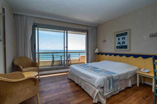 a bedroom with a bed and a view of the ocean at Résidence Vacances Bleues Le Grand Large in Biarritz