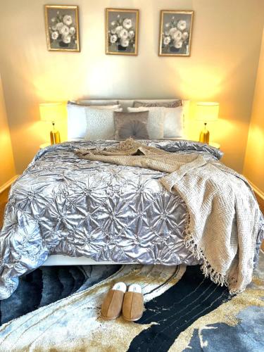 a bedroom with a bed with two lamps and shoes at The Porchlight retreat in Farmington Hills