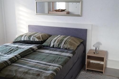 ein Bett in einem Schlafzimmer mit einem Spiegel an der Wand in der Unterkunft Ambiente Ferienapartments Julienhöhe in Niederdorf