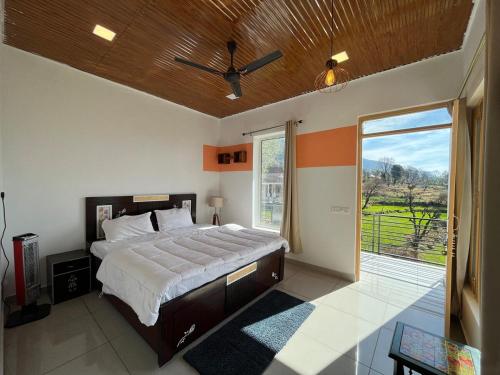 a bedroom with a large bed and a large window at Luxury KA Villa - BIR in Bīr