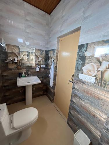 a bathroom with a white toilet and a sink at Luxury KA Villa - BIR in Bīr