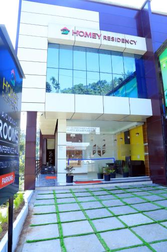 a front view of a building with a pharmacy at Homey Residency vythiri in Padinjarathara
