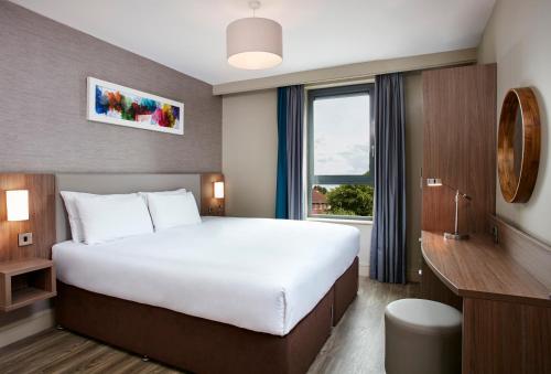a hotel room with a large bed and a window at Cordia Serviced Apartments - Free on-site parking in Belfast