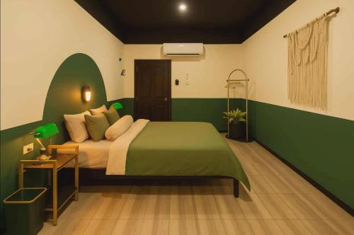 a green and white bedroom with a bed and a table at Jungle Fever Koh Chang in Ko Chang