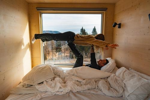 a woman is jumping on top of a bed at Rallentare immersi nel verde di Cima Lan 