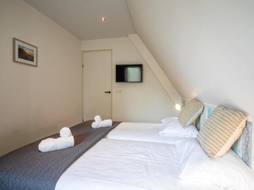 Un dormitorio con dos camas en un ático. en Lovely villa on the edge of the forest, en Westermient