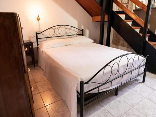a bedroom with a bed with white sheets and a staircase at Holiday Home in Siracusa with garden in Floridia