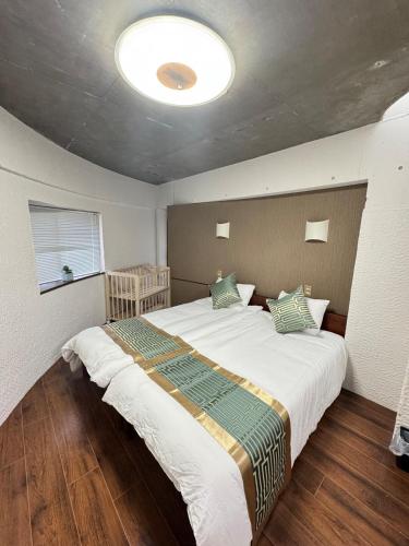 a bedroom with a large bed in a room at MARU KIX House in Izumi-Sano
