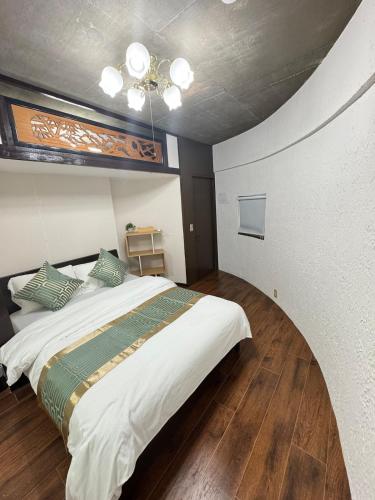 a bedroom with a large bed with a ceiling at MARU KIX House in Izumi-Sano