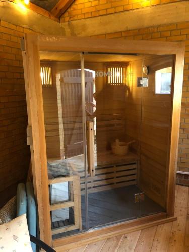a sauna with a glass door in a cabin at Glashüttchen mit 2 Schlafzimmern, Sauna und schönem Garten in Annahütte