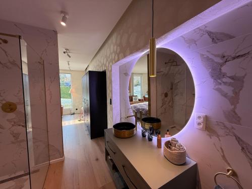 bagno con tavolo da trucco, specchio e doccia. di Beach House in Ardennes a Chaudfontaine