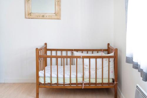 a crib in a room with a picture on the wall at Spacieux T3 cosy au cœur d’Hossegor in Soorts-Hossegor