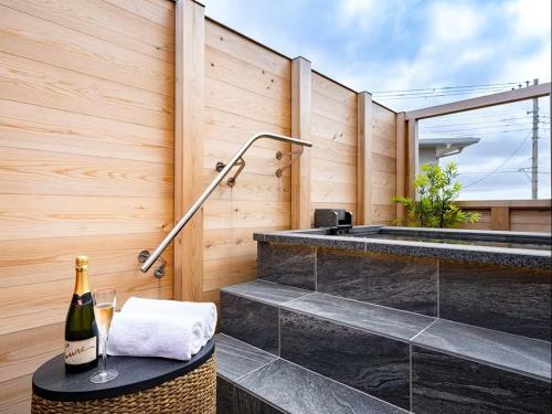 a bathroom with a tub and a table with a bottle of wine at 割烹旅館 清都 in Hongō
