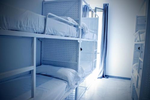 two bunk beds in a room with a window at Feel Hostels Soho Malaga in Málaga